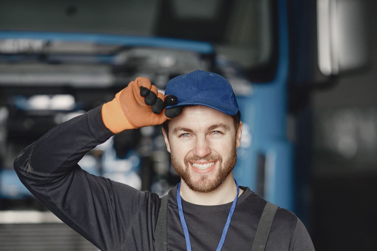 A friendly technician in work overalls smiling at the camera.